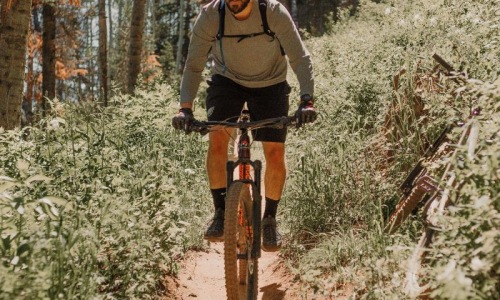 man riding a bike on a trail in the woods
