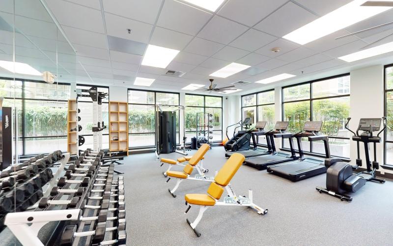 a room with exercise equipment and chairs