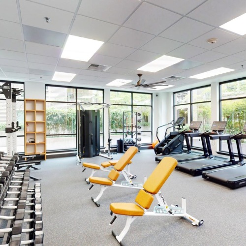 a room with exercise equipment and chairs